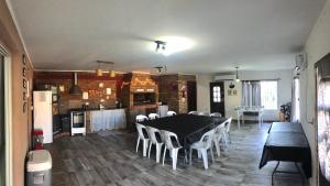 a dining room with a black table and white chairs at Quincho Roca Plottier in Plottier