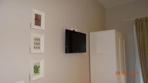 a flat screen tv on a wall with pictures at Smaragdi Studios in Pefkari