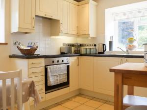 a kitchen with white cabinets and an oven at Herrock View in Evenjobb