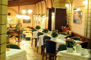 a restaurant with tables and chairs with flowers on them at Hotel Grillo Verde in Torre Annunziata