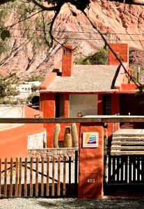 a house with a fence in front of a mountain at Chilcagua in Purmamarca