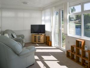 a living room with two chairs and a television at Reflections in Surfleet