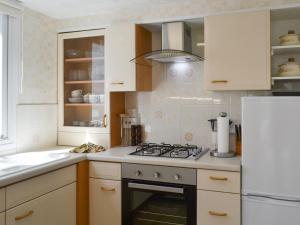 a kitchen with white cabinets and a stove top oven at Reflections in Surfleet