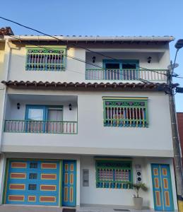 a white house with colorful doors and windows at vista piedra in Guatapé +6 photos