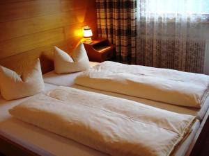 - 2 lits installés l'un à côté de l'autre dans une chambre dans l'établissement Haus Sonnberg, à Mellau