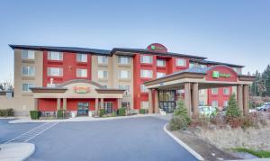 Holiday Inn Spokane Airport, an IHG Hotel في سبوكان: فندق ذو مبنى احمر مع موقف للسيارة