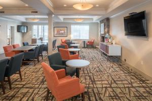 Holiday Inn Spokane Airport, an IHG Hotel في سبوكان: غرفة انتظار في مستشفى مع طاولات وكراسي