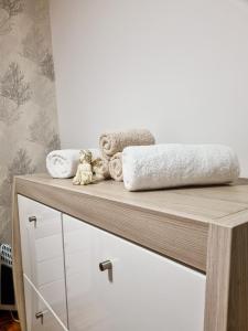 a wooden dresser with towels and stuffed animals on it at AS Delux Apartmani in Soko Banja
