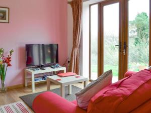 a living room with a red couch and a tv at Spindlestone in Beal