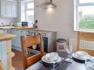 uma cozinha com uma mesa com pratos e copos em Old Reading Room em Cotehill