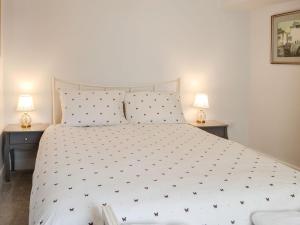 a bedroom with a large white bed with two lamps at Old Reading Room in Cotehill