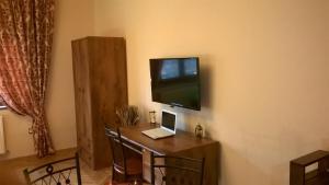 a desk with a laptop and a television on a wall at Mozart Apartments in Cluj-Napoca