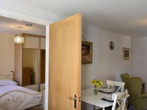 1 dormitorio con cama, mesa y comedor en Rosebank Cottage, en Aldbrough