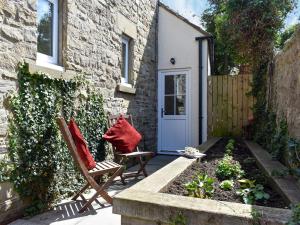 a patio with two chairs in front of a house at Rosebank Cottage in Aldbrough