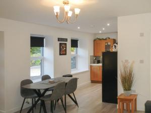 East Lodge في Creebridge: غرفة طعام ومطبخ مع طاولة وكراسي