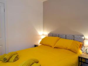 a bedroom with a yellow bed with two bananas on it at East Lodge in Creebridge