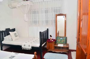 a bedroom with a bed and a mirror and a table at Mihin Villa in Bentota