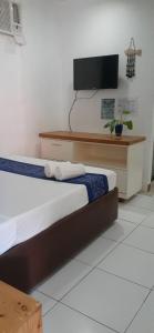 a bedroom with a bed and a tv on a wall at MR Holidays Hotel in Boracay