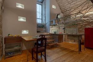 eine Küche mit einem Tisch und einem Schreibtisch in einem Zimmer in der Unterkunft Il Quinto Elemento - Residence Of Charme in Ostuni