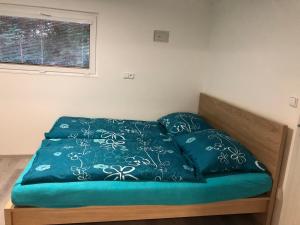 1 cama con edredón azul y 2 almohadas en Ubytování Křtiny en Křtiny