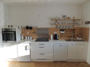 a kitchen with white cabinets and a white refrigerator at Your Ljubljana Home in Ljubljana