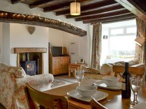 een woonkamer met een tafel en een open haard bij The Tottsie in Bassenthwaite