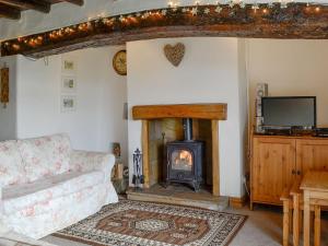 a living room with a fireplace and a couch at The Tottsie in Bassenthwaite