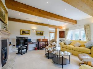 a living room with a couch and a tv at Coach House Cottage in Wotton-under-Edge