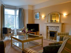 a living room with a table and a fireplace at Linton in Keswick