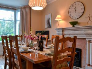 uma sala de jantar com uma mesa e um relógio na parede em Linton em Keswick