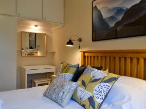 uma cama com almofadas azuis e brancas em Linton em Keswick