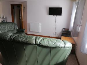 ein Wohnzimmer mit einem grünen Sofa und einem TV in der Unterkunft Impeccable 2-Bed Flat in Wick in Wick
