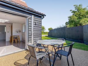 a patio with a table and chairs and a fence at Blackberry Cottage in Stowmarket