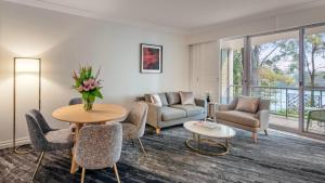 uma sala de estar com uma mesa e cadeiras e uma varanda em InterContinental Sanctuary Cove Resort, an IHG Hotel em Gold Coast