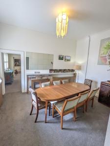 uma sala de jantar com uma mesa de madeira e cadeiras em The F Project Residence - whole house em Warrnambool