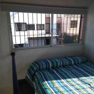 Cama en habitación con ventana en EDU`S HOUSE IIi en Guaymallén
