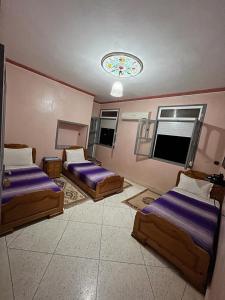 a bedroom with two beds and a chandelier at Ighbola Ouzoud in Ouzoud