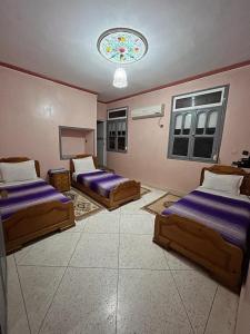 a bedroom with two beds and a chandelier at Ighbola Ouzoud in Ouzoud