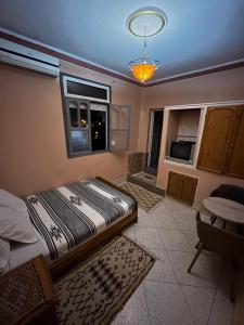 a bedroom with a bed and a table and a window at Ighbola Ouzoud in Ouzoud