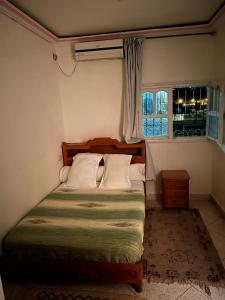 a bedroom with a bed and a window at Ighbola Ouzoud in Ouzoud