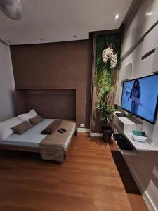 um quarto com uma cama e uma televisão de ecrã plano em Couto Lauredo Ap no Rio de Janeiro