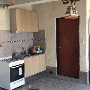 cocina con fregadero, fogones y puerta en EDU`S HOUSE IIi en Guaymallén