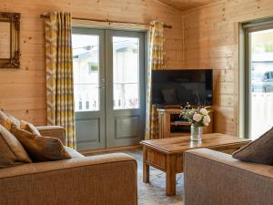 a living room with two couches and a tv at Oak Lodge - Uk30005 in Lindal in Furness