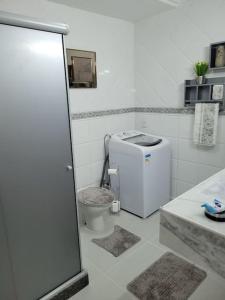 uma casa de banho branca com um WC e um lavatório em Couto Lauredo Ap no Rio de Janeiro