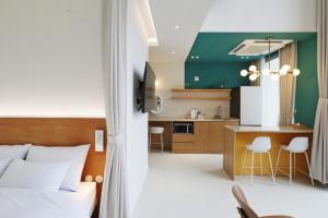 a bedroom with a bed and a kitchen with a counter at Bau Haus in Sokcho