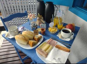 uma mesa azul com um prato de pão e ovos em Mar de Maria Pousada em Búzios