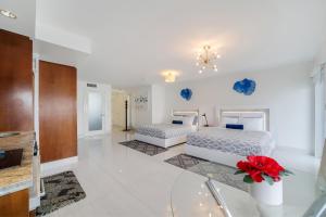 2 camas en una habitación con paredes blancas y suelo blanco en Strand Ocean Drive Suites, en Miami Beach 35 fotos más