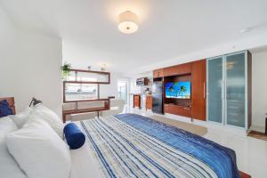 a bedroom with a large bed and a television at Strand Ocean Drive Suites in Miami Beach