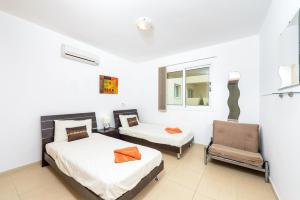 a bedroom with two beds and a chair at Great Kings Resorts in Protaras +14 photos