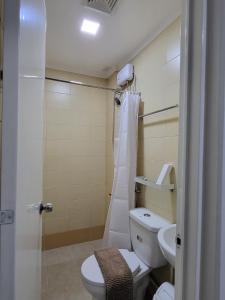 a bathroom with a toilet and a shower and a sink at Rooms R Us - Evangelista in Manila